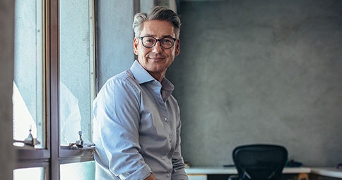 Man sitting on windowsill in a work environment