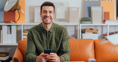 Man using a cell phone and smiling