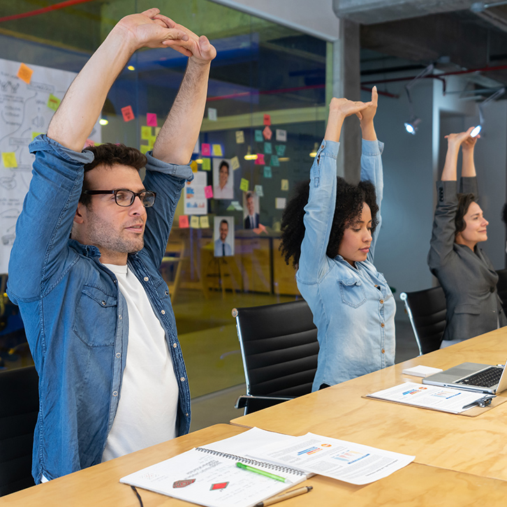 Coworkers stretching at a meeting