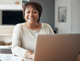 A woman sits at a desk with a computer.