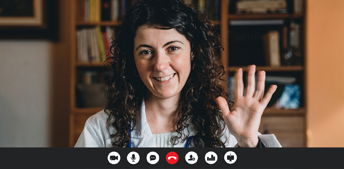 A doctor waves at her patient during a telemedicine visit