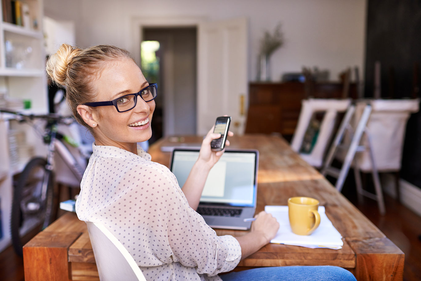 Woman using laptop and phone